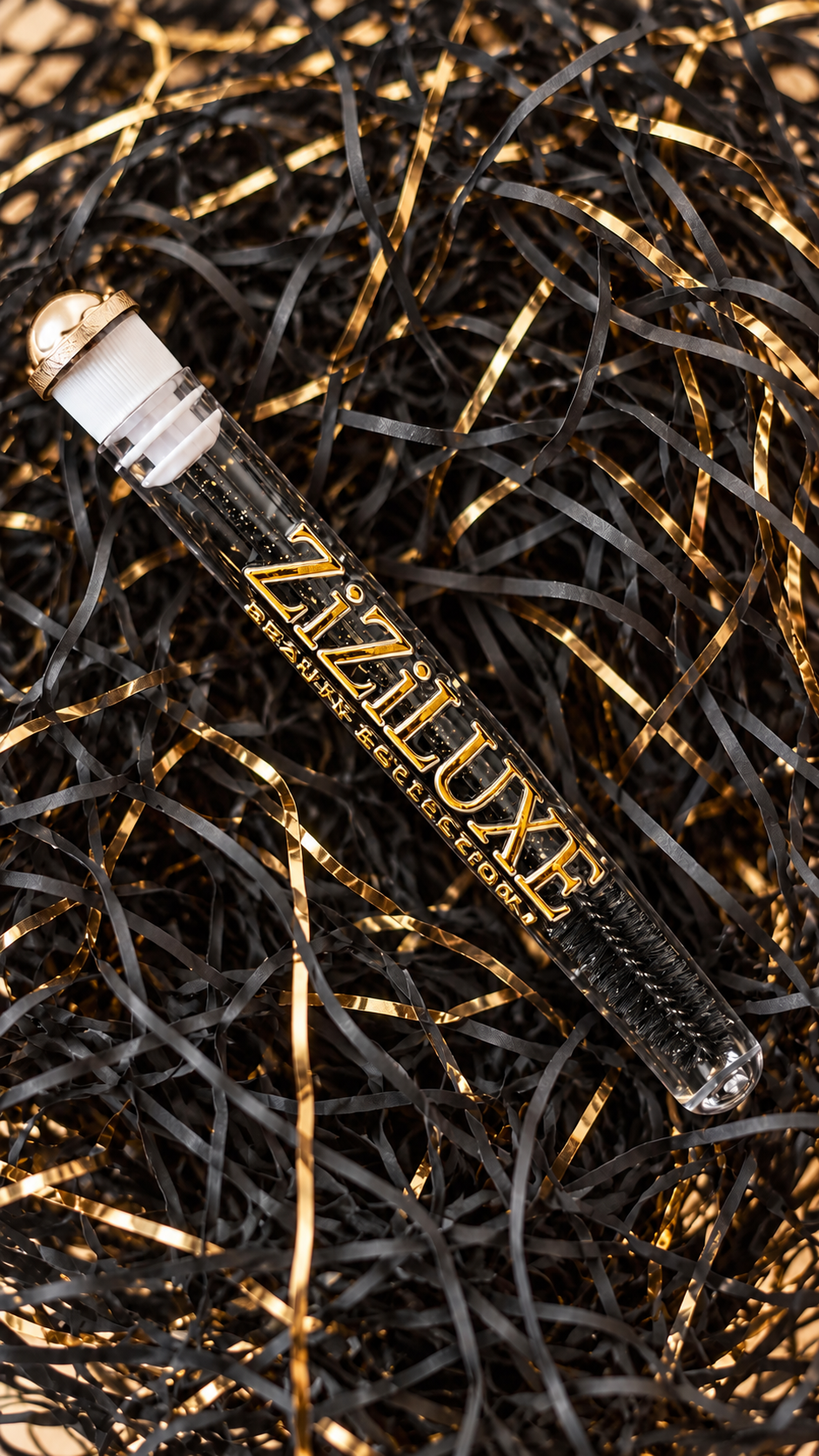ZiZiLUXE cased lash spoolie on black and gold packaging
