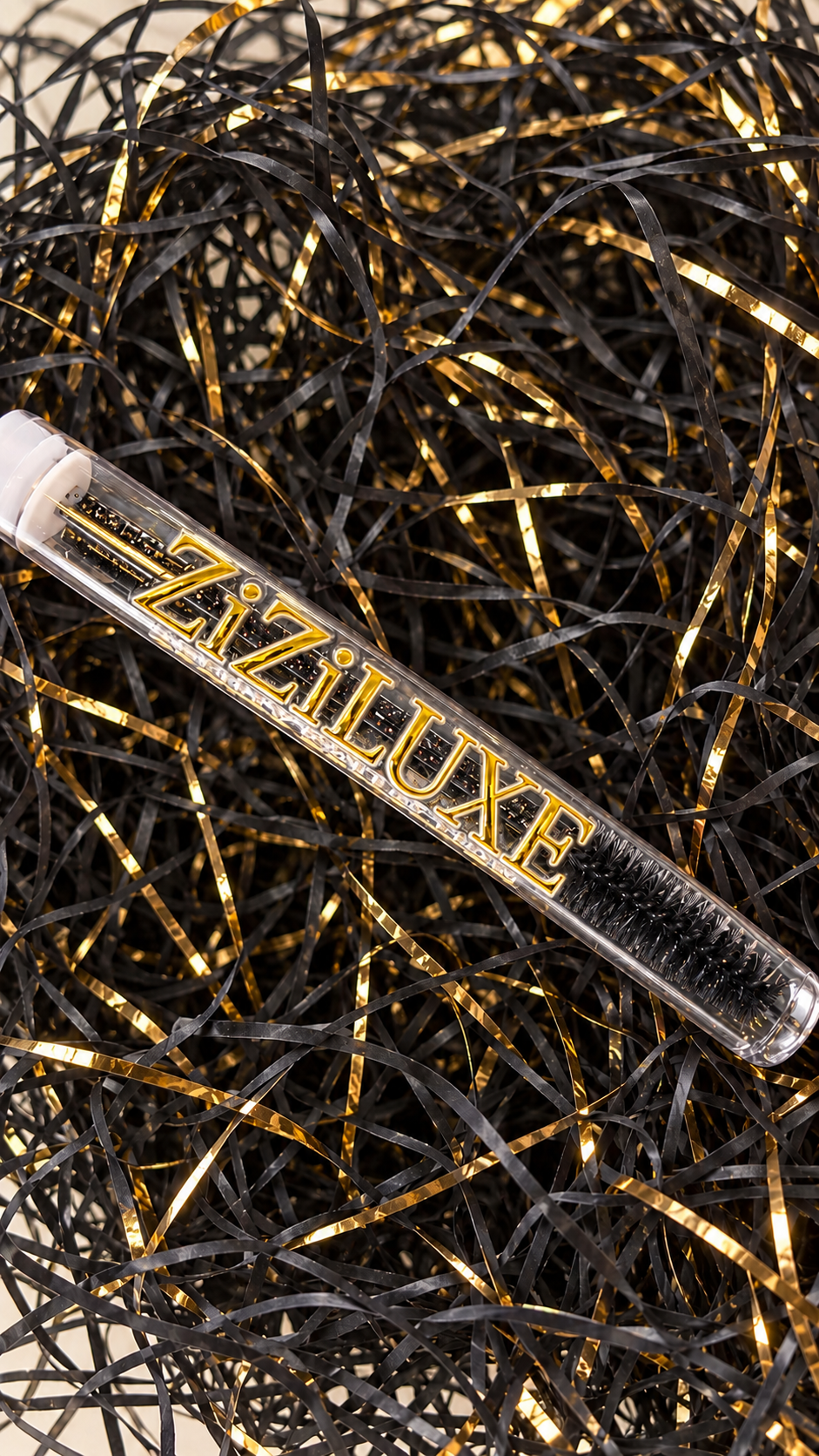 Close-up of black lash spoolie and gold ZiZiLUXE branding